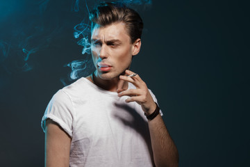 Handsome young man smoking cigarette