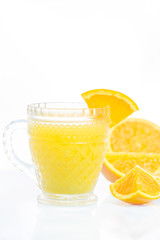 Glass of freshly pressed orange juice with sliced orange half on