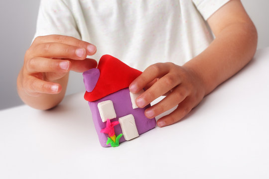 Child buiding a play clay house