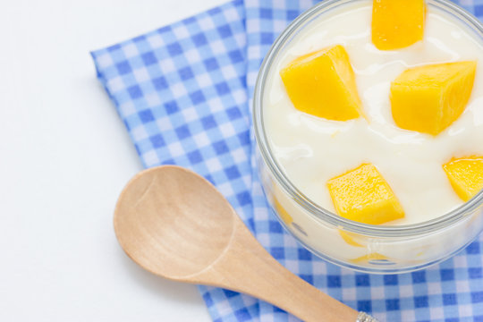 Yoghurt with mango  in a glass jars on white background