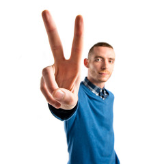 Man making victory gesture over isolated white background