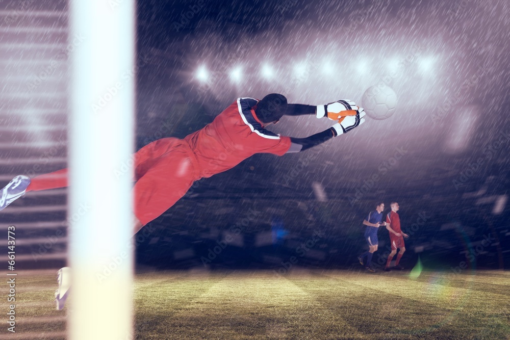 Fototapete composite image of goalkeeper in red making a save