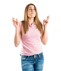 Pretty girl with her fingers crossing over white background