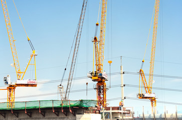 Fototapeta na wymiar Crane at construction site against blue sky