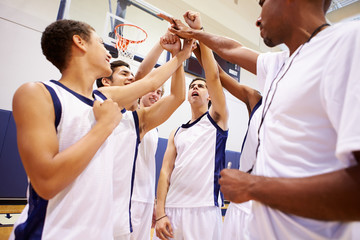 Male High School Basketball Team Having Team Talk With Coach