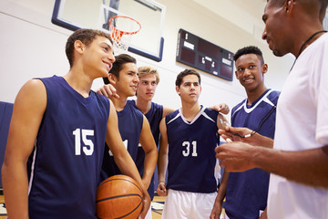 Male High School Basketball Team Having Team Talk With Coach - Powered by Adobe