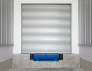 Roller door or roller shutter and dock leveler or height adjustable platform outside warehouse. Use...