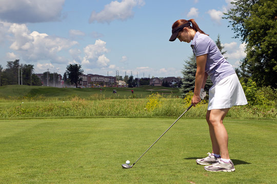 Female golfer prepares to tee off