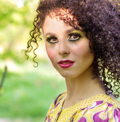 beautiful young little curly-headed girl with makeup