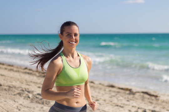 Hispanic woman running on the beach