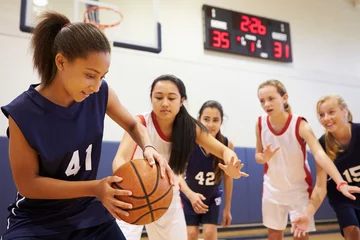 Fototapeten Female High School Basketball Team Playing Game © Monkey Business