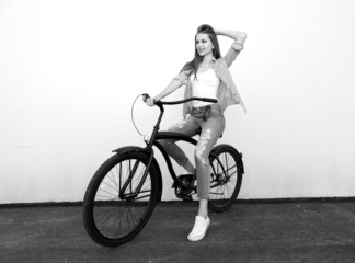 Young hipster girl with black bike