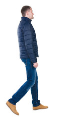 Naklejka premium Back view of going handsome man in jeans and jacket.