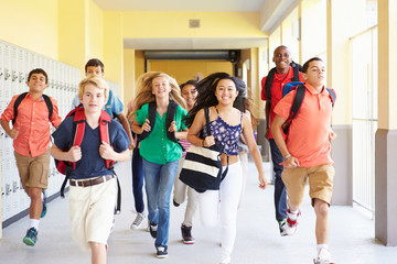 Fototapeta premium Group Of High School Students Running Along Corridor