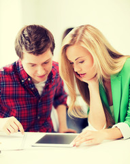 students looking at tablet pc at school