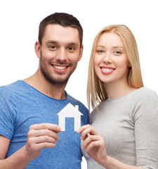 smiling couple holding white paper house