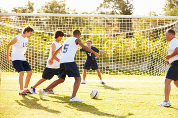 Members Of Male High School Soccer Playing Match