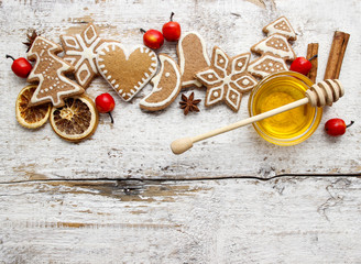 Gingerbread christmas cookies and bowl of honey on wooden table.