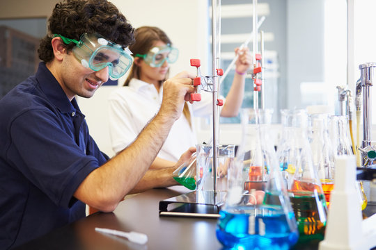 Pupils Carrying Out Experiment In Science Class