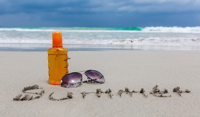 Sunscreen  lotion and dark glasses on the beach  for summer time