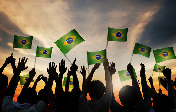 Silhouettes of People Holding the Flag of Brazil