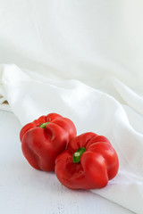 Red peppers on wood and white fabric