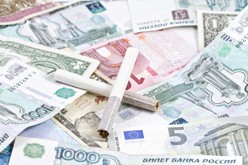 two cigarettes lying on the money