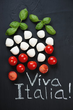 Green basil, mozzarella balls and red tomatoes, above view