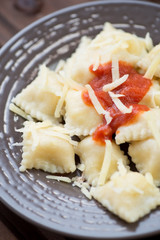Ravioli with tomato sauce and parmesan, vertical shot, close-up