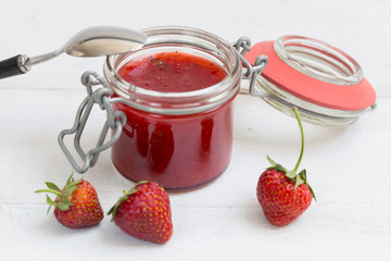 Erdbeermarmelade in einem Einmachglas auf Holz