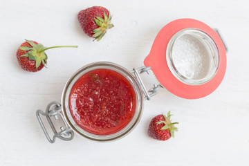 Erdbeermarmelade in einem Einmachglas auf Holz