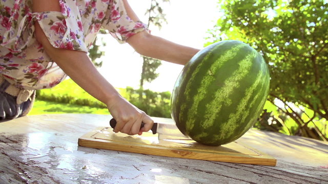 Woman cutting watermelon in slow motion