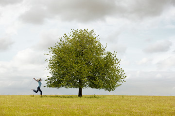 Frau läuft zum Baum