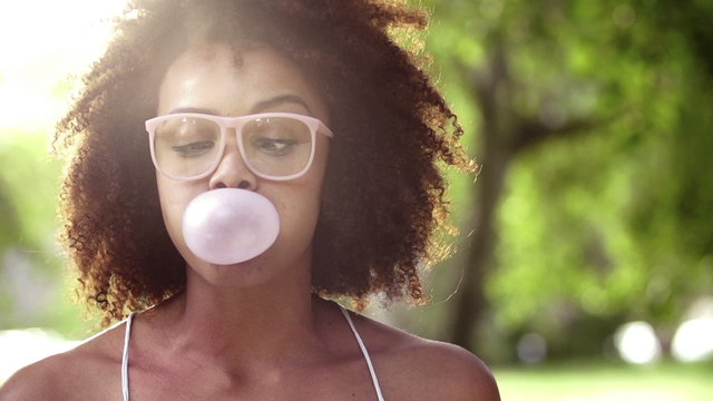 Happy Afro Girl blowing bubble gum in slow motion