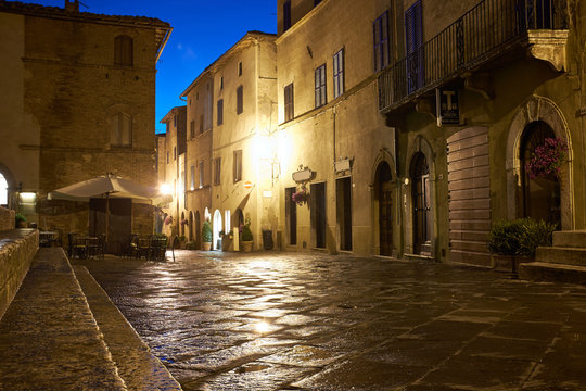 Fototapeta Illuminated Street of Pienza after rain at Night, Italy