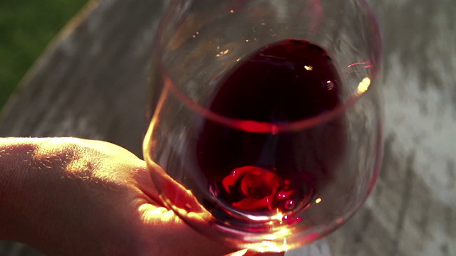Red wine being swirled in wineglass in slow motion