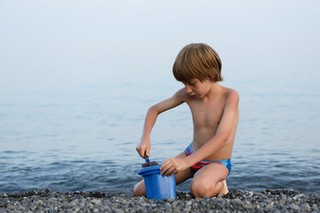 beautiful little boy playing on the beach © Khorzhevska