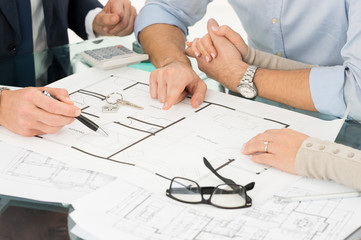 Couple Looking At The Floor Plan Of A House