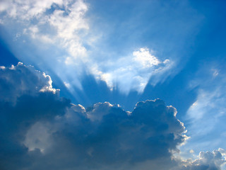 Blue sky with sun rays through the clouds