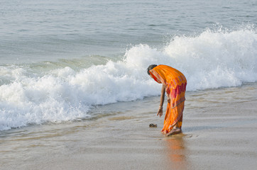 indian woman with colorful sari on sea beach