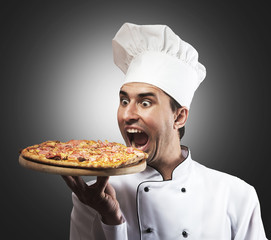 Funny portrait of a chef with opened mouth looking at pizza