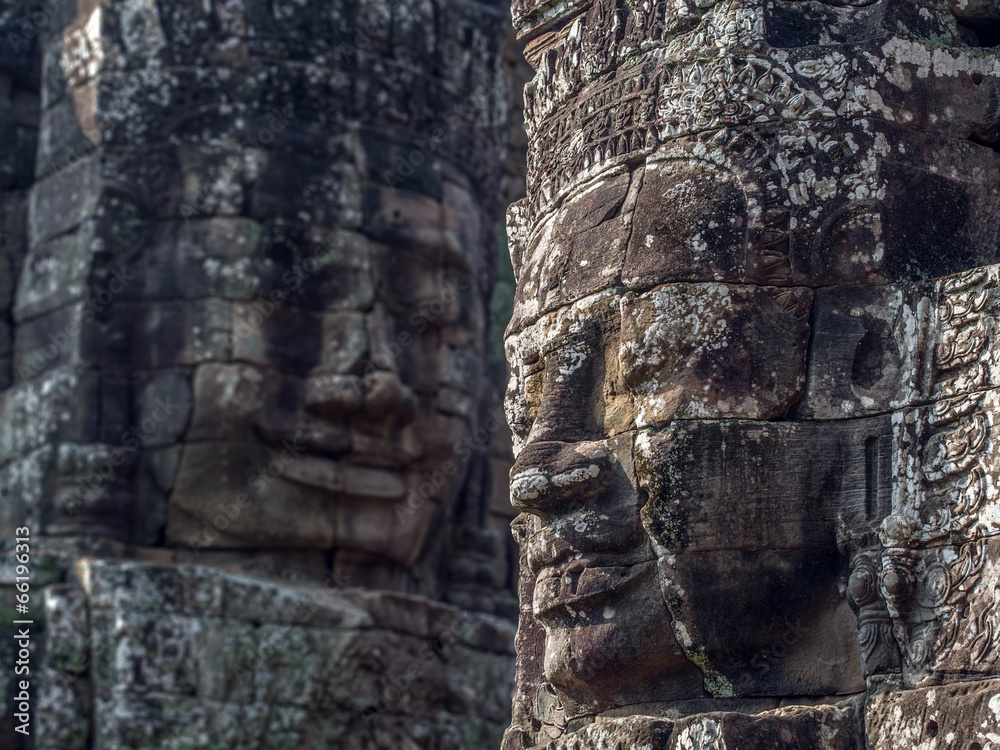 Wall mural giant stone faces at bayon temple at angkor, cambodia