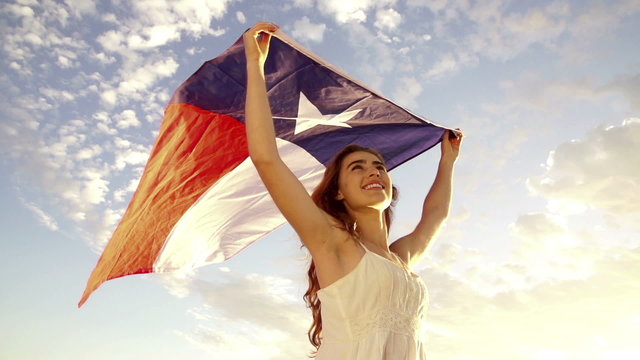 Smiling Woman proudly waving flag of texas in slow motion