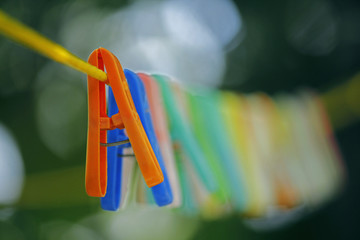 Colorful clothes pegs hanging in wire