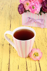 Fragrant tea with flowers on wooden table close-up