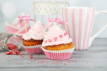 Tasty cup cakes with cream on grey wooden table