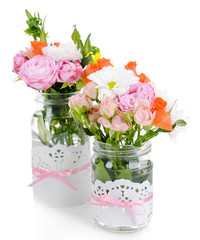 Beautiful bouquet of bright flowers in jars isolated on white