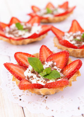Tasty tartlets with strawberries on table close-up