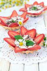 Tasty tartlets with strawberries on table close-up