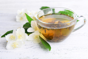 Cup of tea with jasmine on table close-up